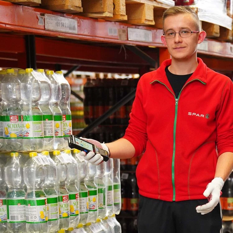 Spar Mitarbeiter mit mobilem Computer Spar Mitarbeiter mit mobilem Computer